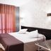 Hospedium Hostal Un Punto Chic in Huesca, a bedroom with double bed, wall TV and sheer curtains