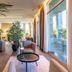 Hsm Hotel San Martino in Garbagnate Monastero lounge with armchairs, plants and floor-to-ceiling windows