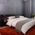 Mint House at 70 Pine in New York guest room with bed, red rug, and window beside chair