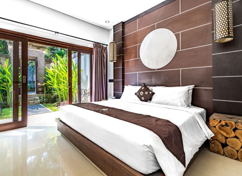 Fullmoon Villa Ubud in Ubud guest room with sliding doors to a tropical patio