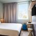 ibis budget Lunel Porte de Camargue guest room in Aimargues with double bed, window, and TV