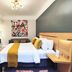 Casa Panuco in Mexico City guest room with king bed, colorful wall art, sofa, and wall-mounted TV