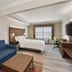 Holiday Inn Express & Suites Byron By IHG guest room with sofa, bed, desk and window view in Byron