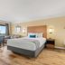 Travelodge by Wyndham San Clemente Beach guest room with king bed, desk, and balcony door