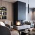 Langwies Genussherberge in Vigaun lounge with fireplace, built-in shelves and upholstered armchairs