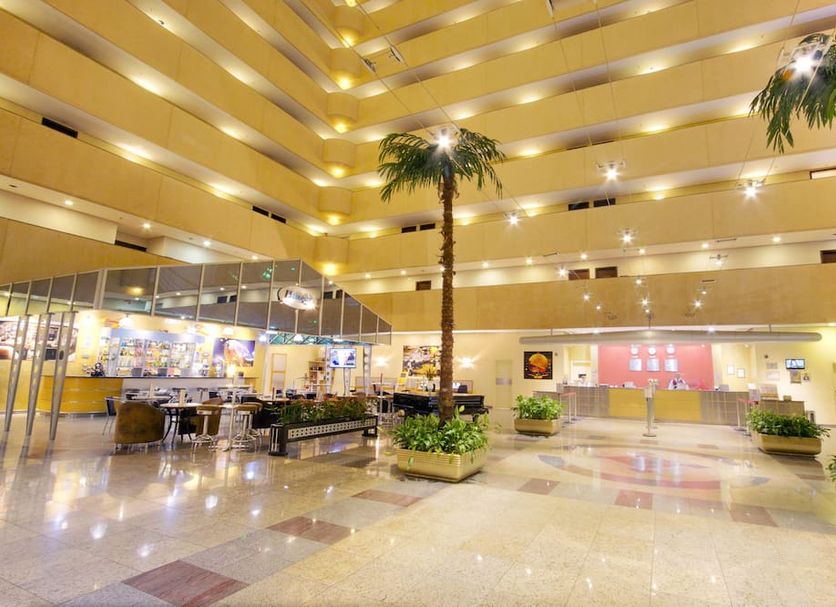 Bristol International Guarulhos lobby atrium with tall palm trees and polished marble floors in Guarulhos