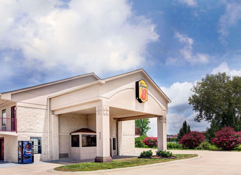 Super 8 by Wyndham Clarksville East exterior with entrance, blue sky, and landscaped grounds