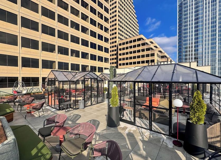 Moxy Cincinnati Downtown rooftop terrace with glass-enclosed seating and city skyline views