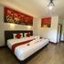 The Krabi Forest Homestay in Ao Nang, guest room with king bed and red floral wall art