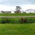 Pacific City Inn in Pacific City with grassy lawn and distant homes under a cloudy sky