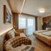 Hotel Waldfrieden in Rohrmoos guest room with wooden bed, sofa, and balcony doors