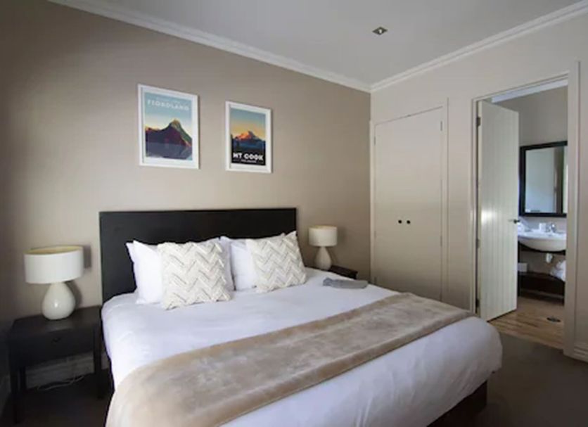 Cardrona Hotel Wanaka guest room with king bed, bedside lamps, and framed wall art