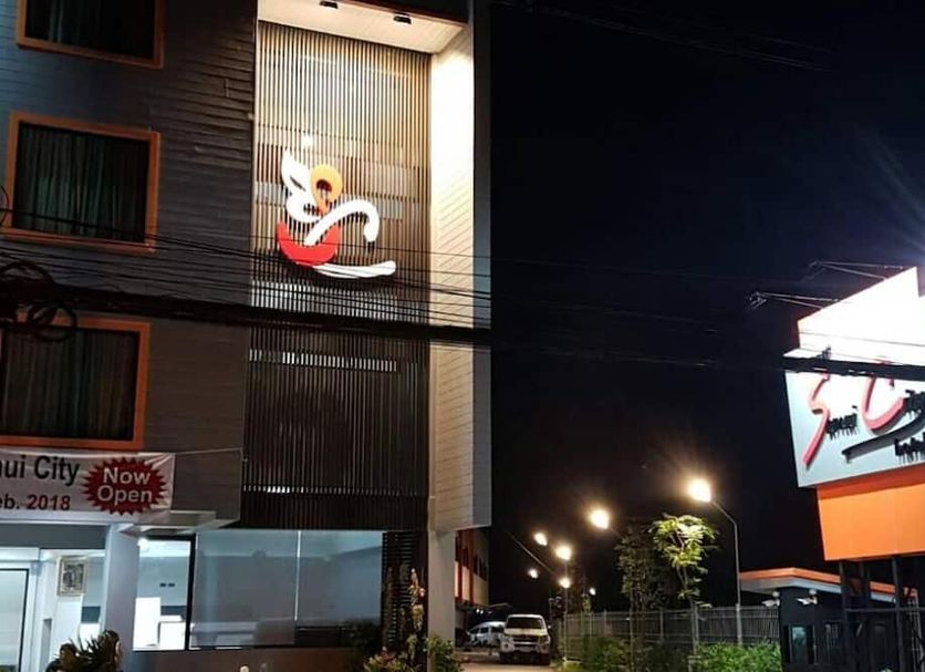 Samui City Hotel in Ko Samui at night with illuminated exterior sign and street view