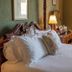 Lochinver Guest House in Ayr bedroom with four-poster bed, bedside lamps and armchair