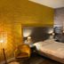Strandhotel Vigilante in Makkum guest room with double bed, textured gold wall and woven pendant lights