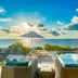 Sailrock South Caicos in Cockburn Harbour with oceanfront pool and sun loungers at sunset