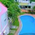 Volga Apartment Hotel in Mũi Né with a curved outdoor pool surrounded by palm trees