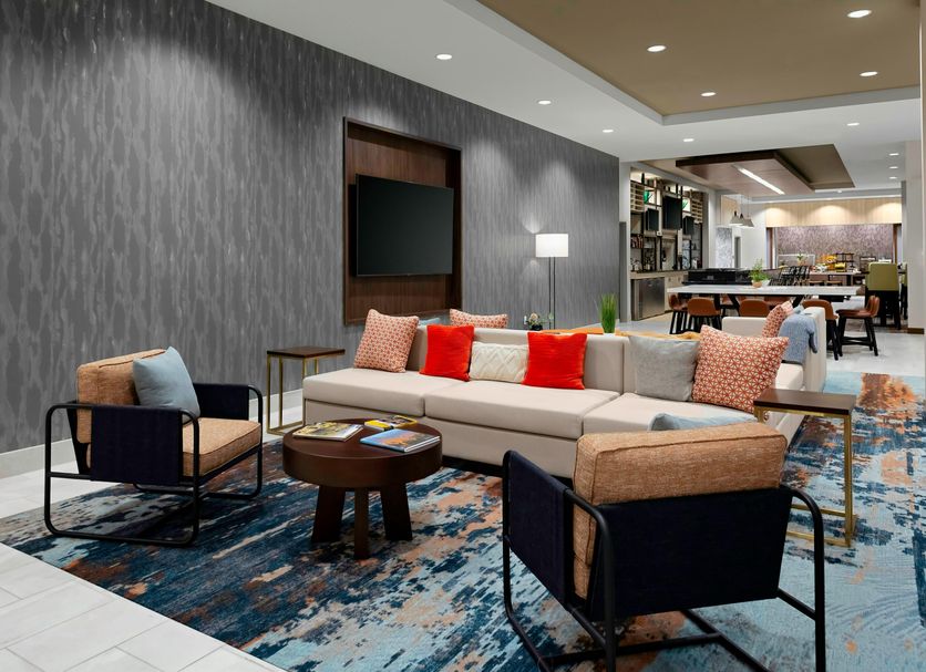 Hilton Garden Inn Chandler Downtown lobby lounge with sectional seating, patterned rug, and TV