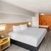 Days Inn by Wyndham Harrisonburg guest room with king bed, desk, chair and wall-mounted TV