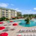 Silver Lake Resort in Kissimmee with a large outdoor pool, island fountain, and red umbrella lounge chairs