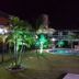Hotel Pousada Cumbuco Gold in Cumbuco with a lit outdoor pool and palm trees at night