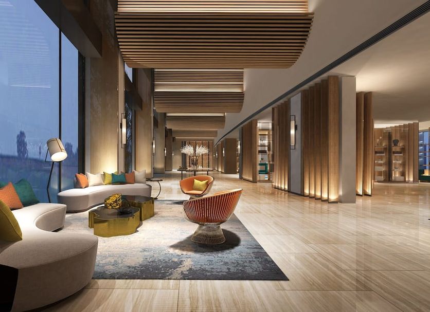 The Qube Hotel Shanghai Sanjiagang lobby with lounge seating, wood-slat ceiling and city-view windows in Shanghai