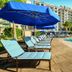 Disney's Riviera Resort in Lake Buena Vista with poolside loungers and blue umbrellas beside a resort pool