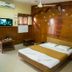 Hotel Chanma International, Coimbatore room with double bed, wood-paneled wall and wall-mounted TV