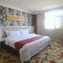 Spring Hotel Dalian guest room with double bed, floral wallpaper, large window and desk