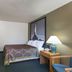 Super 8 by Wyndham Houghton Lake room with king bed, desk, lamp and kitchenette area