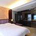 Oriental Hotel Dongguan guest room with king bed, bedside lamps, and glass partition