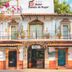 Hotel Posada De Roger in Puerto Vallarta facade with balcony, tiled roof, and flowering vines