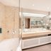 Hilton Frankfurt Gravenbruch bathroom with marble vanity, bathtub, and large mirror in Neu Isenburg