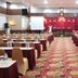 The Nagoya Plasa Redpartner in Batam ballroom with rows of banquet tables and a red curtained stage