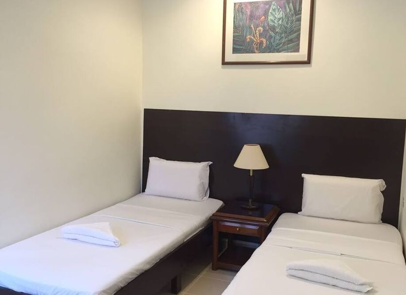 Perhentian Tivoli Inn in Kecil twin room with two single beds, bedside lamp, and framed wall art