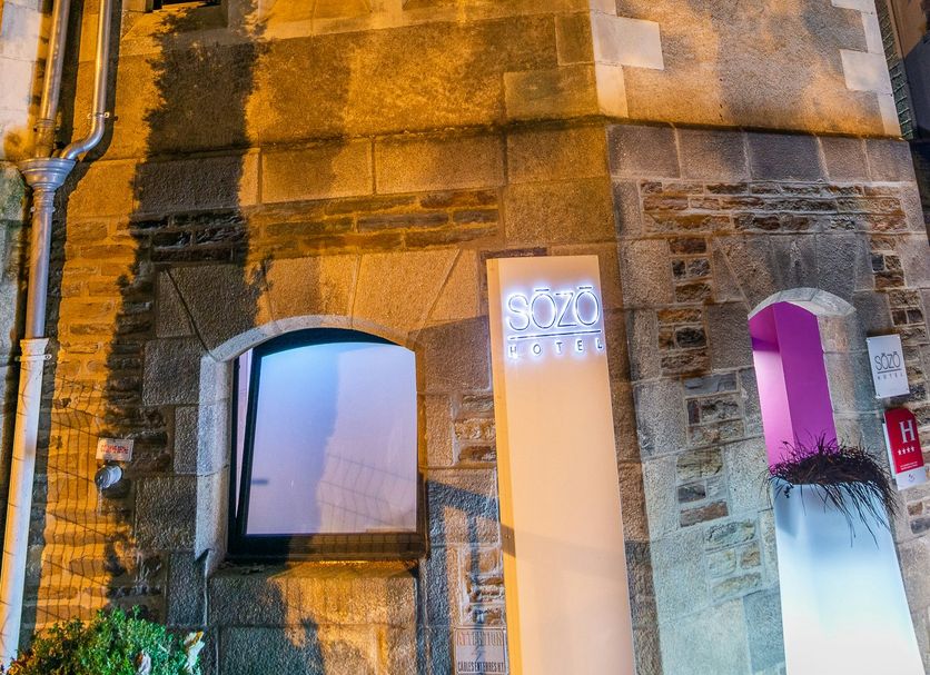 Sozo Hotel Nantes exterior in a historic stone church with illuminated arched windows at night