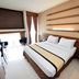 Hotel Nyland Pasteur Bandung guest room with double bed, desk, chair, and large window in Bandung