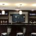 Best Western Plus Goodman Inn & Suites in Horn Lake bar area with TV, liquor shelves and pendant lights