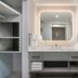 Homewood Suites by Hilton Fresno bathroom vanity with lit mirror and open shelving