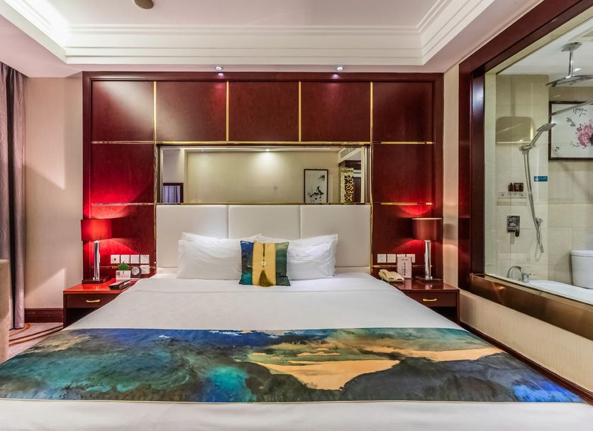Shijiazhuang Shen Zhou 7 Star Hotel room with bed, red wood paneling, and bathroom view in Shijiazhuang