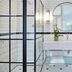 Cape Cadogan Boutique Hotel in Cape Town bathroom with glass shower, round mirror, and double vanity