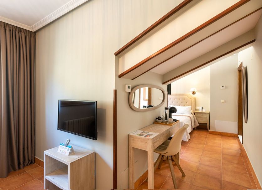 Logis Hotel Restaurante La Casa de Juansabeli in Las Arenas: cozy room with desk, TV, and bedroom area