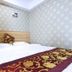 Center Of City Creo Hotel in Yanbian guest room with double bed, bedside lamp, and patterned wallpaper