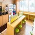 Super Hotel Gotsu-Ekimae in Gōtsu: bright breakfast area with vending machines, stools, and window seating
