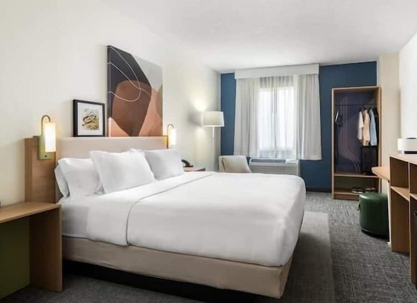 Spark by Hilton Erie guest room with king bed, window, TV, wardrobe and desk