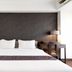 Lily Hotel Bangkok room with king bed, patterned headboard wall, bedside lamps, and desk in Bangkok