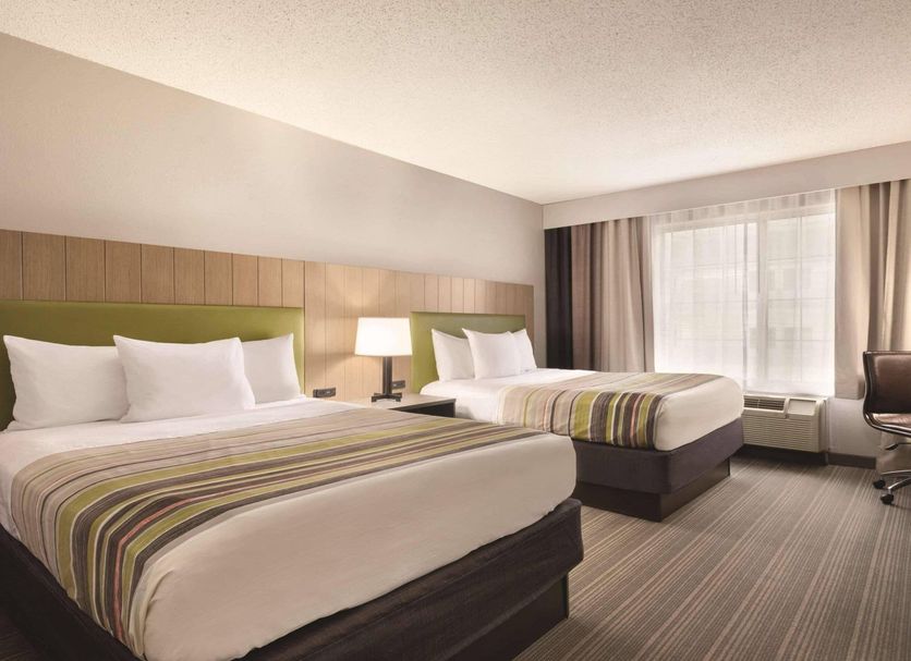 Country Inn & Suites by Radisson, Merrillville, IN guest room with two beds and a window seat
