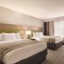 Country Inn & Suites by Radisson, Merrillville, IN guest room with two beds and a window seat