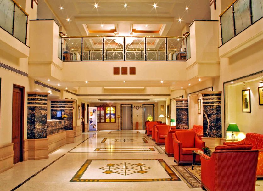 Aditya Park Hyderabad lobby with red seating, marble floors, and mezzanine balcony