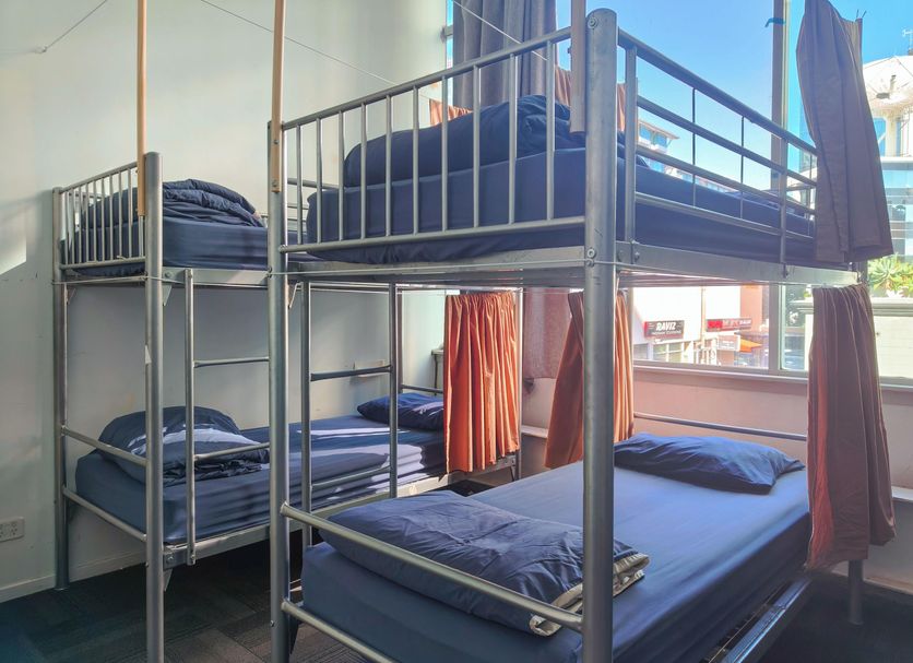 Metro Adventurer Backpackers Auckland shared room with metal bunk beds and blue bedding